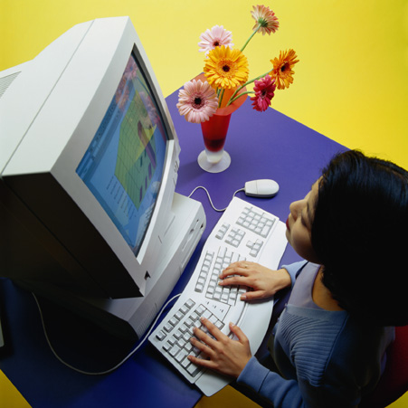 female employee typing on her computer while looking at the monitor.